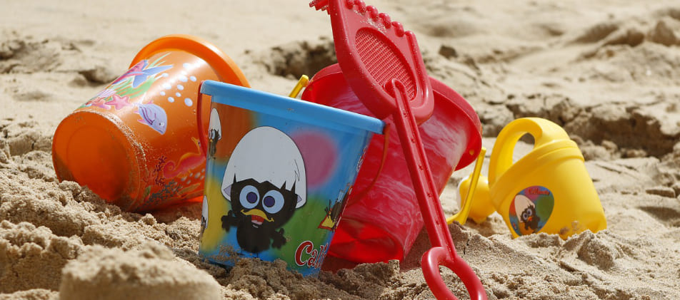 Eimerchen und Harke - Kinderspielzeug am Strand steht für den Familienurlaub am Meer dank Schuldenhilfe durch Schuldnerberater der Schuldner-Hotline Bremen Lesum